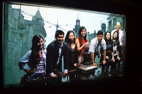A group of the class poses for a group picture with a shot of old Shanghai in the background.
