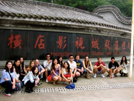 Popping a squat in front of the Hengdian World Studios sign.