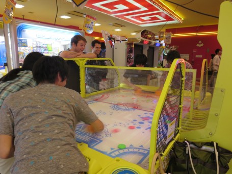 Meiji and USC students playing the intense version of Air Hockey