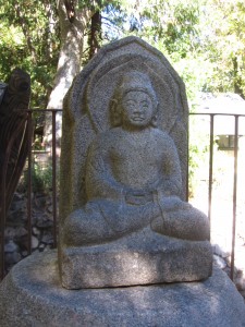 Stone Buddha statue at Tassajara illustrating the cross-legged meditation posture. 